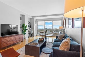 Living room flooded with natural light at The Amelia Apartments in Quincy, MA